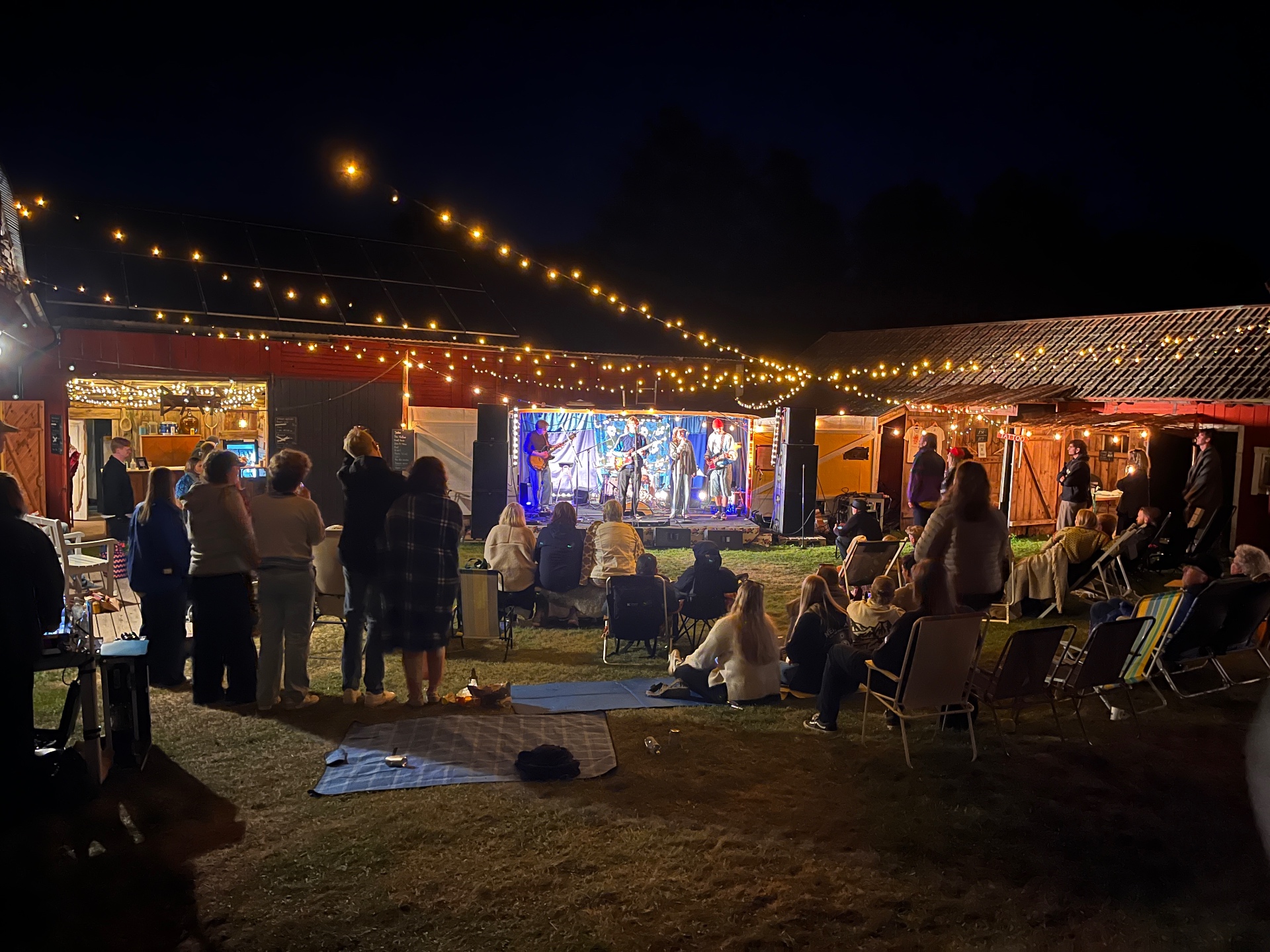 Kvällsstämning på Kärrgårdsfesten med ljusslingor och scen
